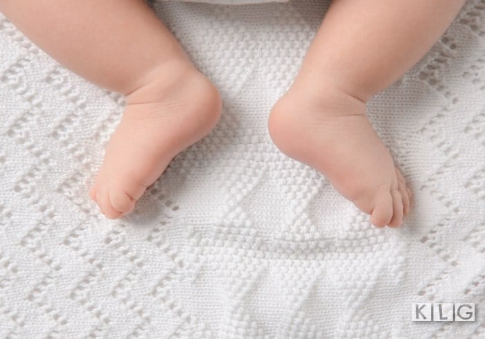 Knitted baby blanket with baby feet