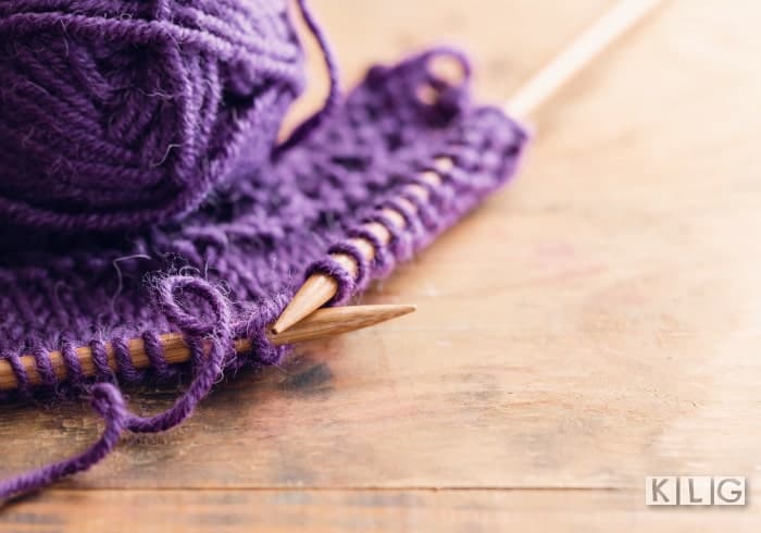 Purple wool and knitting on needles