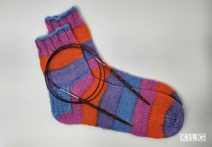 Socks made with self striping yarn in purple orange blue and pink