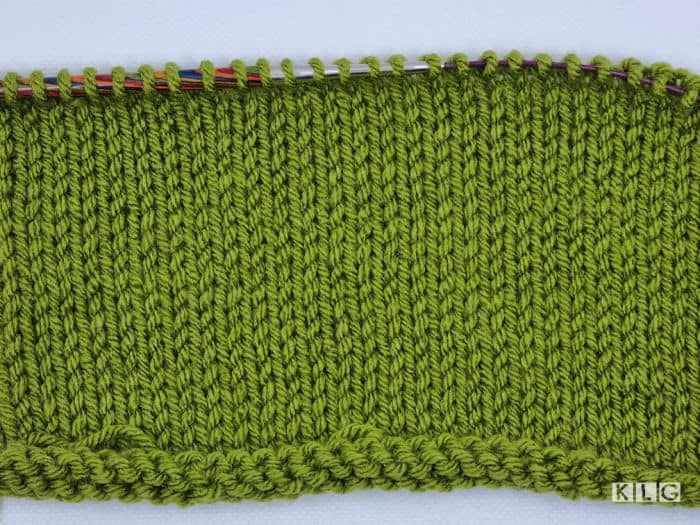 Stockinette stitch knitted by me in Avocado Green acrylic yarn