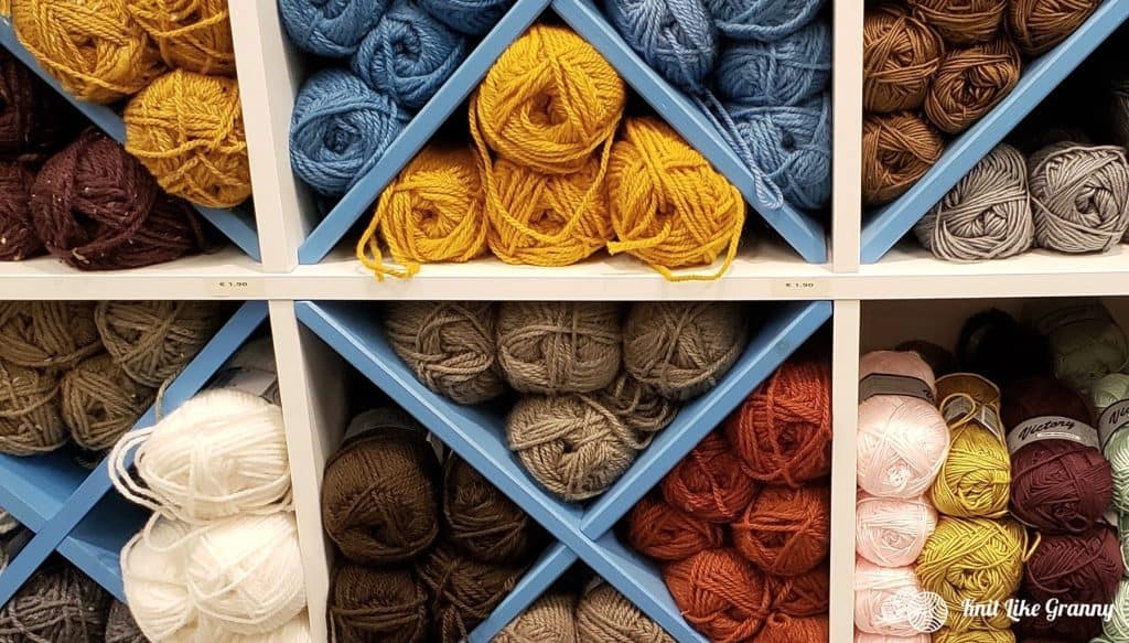 Diagonal shelves of yarn arranged by color.